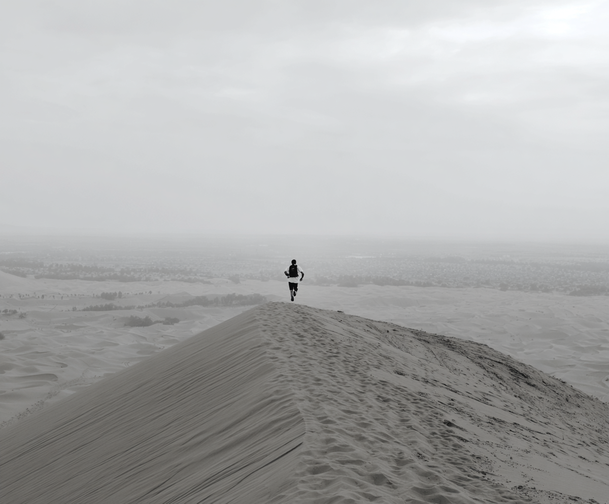enbe228_man_runs_down_a_huge_sand_dune_--chaos_5_--ar_65_--ra_374bf4fa-fede-4a05-8810-98202af049bb_0